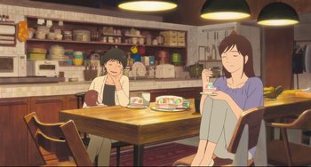 Movie still from “Mirai” (2018), directed by Mamoru Hosoda – Two women sitting at a table in front of a cake; Wide shot, High angle