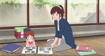 Movie still from “Mirai” (2018), directed by Mamoru Hosoda – A woman sitting on the ground next to a child; Wide shot, High angle