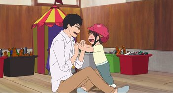 Movie still from “Mirai” (2018), directed by Mamoru Hosoda – A man and a child are playing with each other; Medium shot, High angle