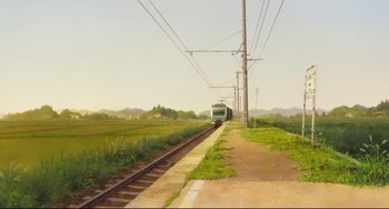 Movie still from “Mirai” (2018), directed by Mamoru Hosoda – A train traveling down train tracks next to a field; Extreme Wide shot, Low angle
