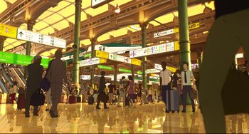 Movie still from “Mirai” (2018), directed by Mamoru Hosoda – A group of people standing in an airport terminal with suitcases; Extreme Wide shot, High angle