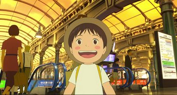 Movie still from “Mirai” (2018), directed by Mamoru Hosoda – A boy with a straw hat standing in a train station; Medium shot, Low angle