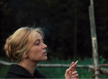 Movie still from “Mirror” (1975), directed by Andrei Tarkovsky – A woman holding a cigarette in her mouth; Close Up shot, Over the shoulder angle