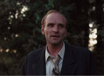 Movie still from “Mirror” (1975), directed by Andrei Tarkovsky – A person wearing a suit and a tie; Close Up shot, Low angle