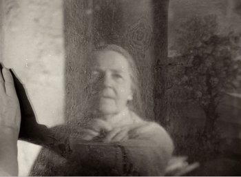 Movie still from “Mirror” (1975), directed by Andrei Tarkovsky – An old woman standing in front of a glass window; Close Up shot, Low angle