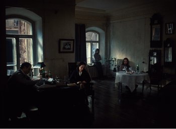 Movie still from “Mirror” (1975), directed by Andrei Tarkovsky – A group of people sitting at a table in front of a window; Wide shot, High angle