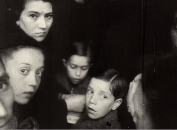Movie still from “Mirror” (1975), directed by Andrei Tarkovsky – A black and white photo of a group of people; Close Up shot, High angle