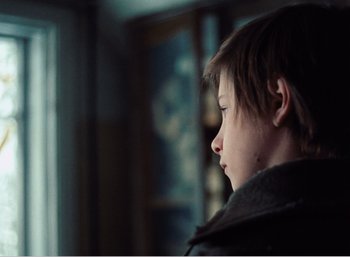 Movie still from “Mirror” (1975), directed by Andrei Tarkovsky – A young boy is looking out a window; Close Up shot, Over the shoulder angle