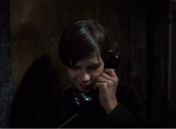 Movie still from “Mirror” (1975), directed by Andrei Tarkovsky – A person talking on a phone in a dark room; Close Up shot, High angle