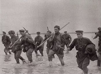 Movie still from “Mirror” (1975), directed by Andrei Tarkovsky – A black and white photo of soldiers wading through water; Wide shot, High angle