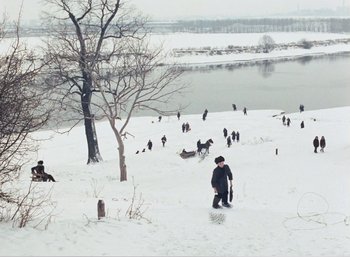Movie still from “Mirror” (1975), directed by Andrei Tarkovsky – A group of people in the snow near a body of water; Extreme Wide shot, High angle