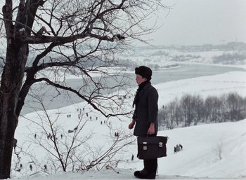 Movie still from “Mirror” (1975), directed by Andrei Tarkovsky – A woman standing on a snowy hill holding a briefcase; Extreme Wide shot, High angle