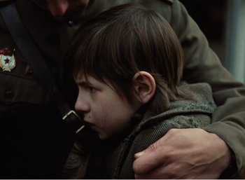 Movie still from “Mirror” (1975), directed by Andrei Tarkovsky – A young boy is being held by his father; Close Up shot, Over the shoulder angle
