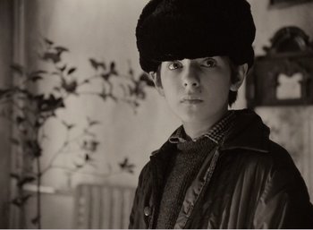 Movie still from “Mirror” (1975), directed by Andrei Tarkovsky – A young man wearing a fur hat and a jacket; Close Up shot, High angle