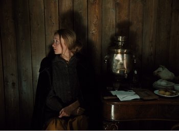 Movie still from “Mirror” (1975), directed by Andrei Tarkovsky – A woman sitting on a chair next to an urn; Medium shot, High angle