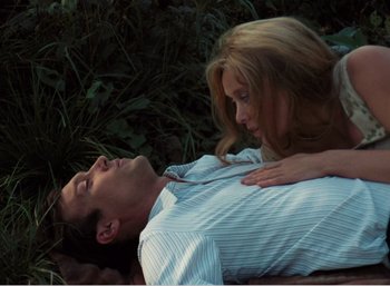 Movie still from “Mirror” (1975), directed by Andrei Tarkovsky – A man and a woman laying in the grass; Medium shot, Overhead angle