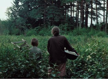 Movie still from “Mirror” (1975), directed by Andrei Tarkovsky – A woman and a boy are walking through the woods; Wide shot, Over the shoulder angle