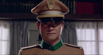Movie still from “Mishima: A Life in Four Chapters” (1985), directed by Paul Schrader – A person wearing a uniform; Close Up shot, Low angle