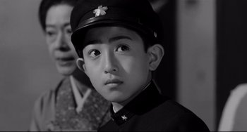 Movie still from “Mishima: A Life in Four Chapters” (1985), directed by Paul Schrader – A young man wearing a hat and a uniform; Close Up shot, Low angle