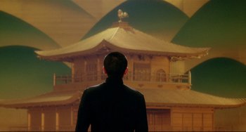 Movie still from “Mishima: A Life in Four Chapters” (1985), directed by Paul Schrader – A man standing in front of an oriental building; Medium shot, Low angle