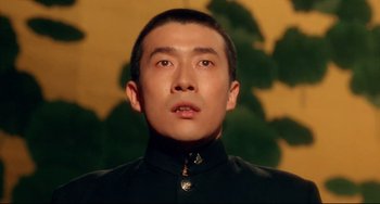 Movie still from “Mishima: A Life in Four Chapters” (1985), directed by Paul Schrader – A person wearing a black shirt; Close Up shot, Low angle