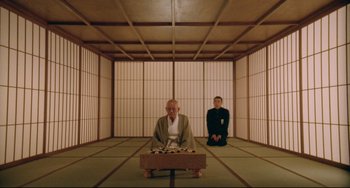 Movie still from “Mishima: A Life in Four Chapters” (1985), directed by Paul Schrader – Two men sitting in a room with a table; Wide shot, High angle