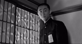 Movie still from “Mishima: A Life in Four Chapters” (1985), directed by Paul Schrader – A man in a suit standing in front of a window; Close Up shot, Low angle