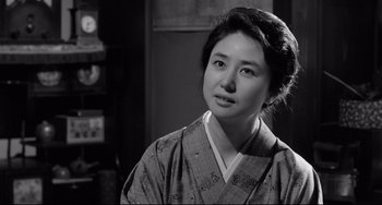 Movie still from “Mishima: A Life in Four Chapters” (1985), directed by Paul Schrader – A woman in a kimono is looking at the camera; Close Up shot, Over the shoulder angle