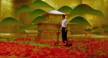 Movie still from “Mishima: A Life in Four Chapters” (1985), directed by Paul Schrader – A man standing in front of an asian building with red leaves; Extreme Wide shot, Low angle