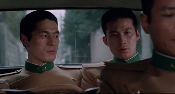 Movie still from “Mishima: A Life in Four Chapters” (1985), directed by Paul Schrader – Two asian men sitting in the back seat of a car; Close Up shot, Low angle