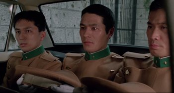Movie still from “Mishima: A Life in Four Chapters” (1985), directed by Paul Schrader – A man sitting in the back seat of a car; Close Up shot, Low angle