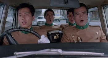 Movie still from “Mishima: A Life in Four Chapters” (1985), directed by Paul Schrader – A group of men in brown uniforms in a car; Medium shot, Low angle
