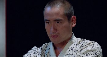 Movie still from “Mishima: A Life in Four Chapters” (1985), directed by Paul Schrader – A person wearing a robe; Close Up shot, Low angle