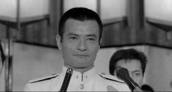 Movie still from “Mishima: A Life in Four Chapters” (1985), directed by Paul Schrader – A black and white photo of a man in a military uniform; Close Up shot, Low angle