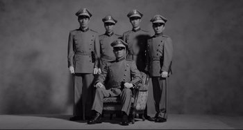 Movie still from “Mishima: A Life in Four Chapters” (1985), directed by Paul Schrader – A group of men in uniform posing for a picture; Wide shot, Low angle