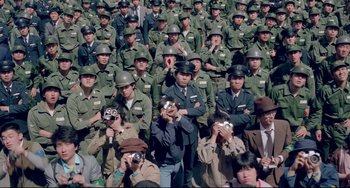 Movie still from “Mishima: A Life in Four Chapters” (1985), directed by Paul Schrader – A large group of people in military uniforms taking pictures; Extreme Wide shot, High angle