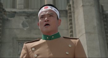 Movie still from “Mishima: A Life in Four Chapters” (1985), directed by Paul Schrader – A man in a military uniform wearing a headband; Close Up shot, Low angle