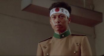 Movie still from “Mishima: A Life in Four Chapters” (1985), directed by Paul Schrader – A man in a military uniform wearing a headband; Close Up shot, Low angle