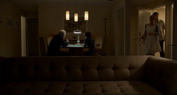 Movie still from “Miss Peregrine's Home for Peculiar Children” (2016), directed by Tim Burton – Two people sitting at a table in a living room; Wide shot, High angle