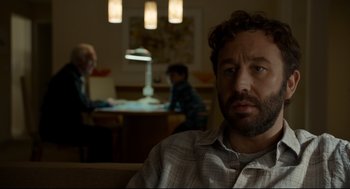 Movie still from “Miss Peregrine's Home for Peculiar Children” (2016), directed by Tim Burton – A man sitting in front of two other people in a room; Close Up shot, Over the shoulder angle