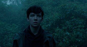 Movie still from “Miss Peregrine's Home for Peculiar Children” (2016), directed by Tim Burton – A young man standing in front of a forest; Close Up shot, High angle