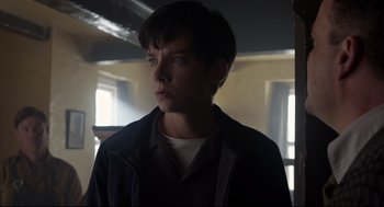 Movie still from “Miss Peregrine's Home for Peculiar Children” (2016), directed by Tim Burton – A young man in a dark room looking to his left; Close Up shot, Low angle