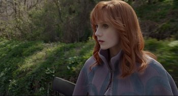 Movie still from “Miss Peregrine's Home for Peculiar Children” (2016), directed by Tim Burton – A woman with red hair sitting on top of a wooden bench; Close Up shot, Over the shoulder angle