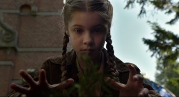 Movie still from “Miss Peregrine's Home for Peculiar Children” (2016), directed by Tim Burton – A young girl with pigtails is looking at the camera; Close Up shot, Low angle