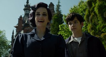 Movie still from “Miss Peregrine's Home for Peculiar Children” (2016), directed by Tim Burton – A woman and a man standing next to each other; Medium shot, Low angle