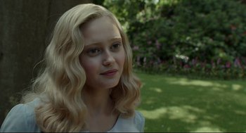 Movie still from “Miss Peregrine's Home for Peculiar Children” (2016), directed by Tim Burton – A young girl with long blonde hair is posing for a picture; Close Up shot, Over the shoulder angle