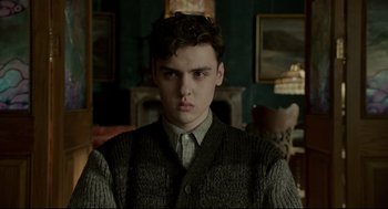 Movie still from “Miss Peregrine's Home for Peculiar Children” (2016), directed by Tim Burton – A young man in a sweater stares at the camera; Close Up shot, Low angle