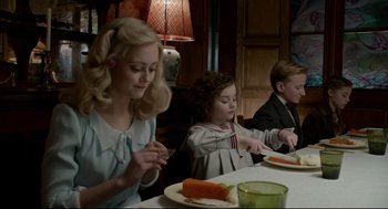 Movie still from “Miss Peregrine's Home for Peculiar Children” (2016), directed by Tim Burton – A group of people sitting at a table with plates of food; Medium shot, Over the shoulder angle