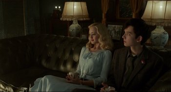 Movie still from “Miss Peregrine's Home for Peculiar Children” (2016), directed by Tim Burton – A woman sitting on a couch next to a man; Medium shot, Over the shoulder angle