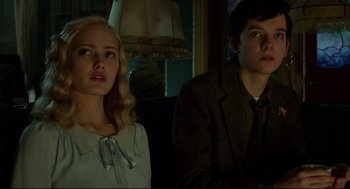 Movie still from “Miss Peregrine's Home for Peculiar Children” (2016), directed by Tim Burton – A young man and a young woman sitting next to each other; Medium shot, Low angle